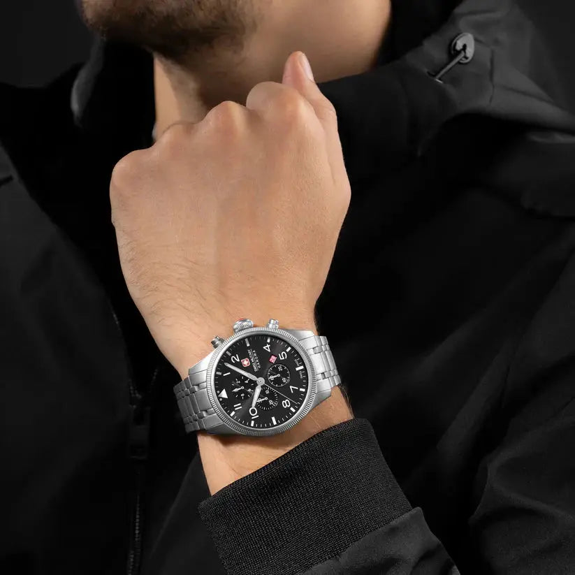 Swiss Military Hanowa SMWGI0000405 Thunderbolt Chrono herenhorloge 43mm met zilveren roestvrijstalen band en zwarte wijzerplaat, gedragen door man in zwarte jas. Ideaal sportief horloge voor heren, verkrijgbaar bij horlogeoutlet.nl.