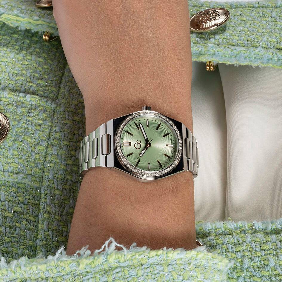 Gc Classic Dameshorloge 34mm - Z38001L9MF met zilverkleurige band en mintgroene wijzerplaat, gedragen om de pols op een groene jas