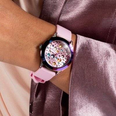 Guess Mini Wonderlust Horloge 34mm - GW0678L3 met roze siliconen band en kleurrijke wijzerplaat, gedragen door een vrouw in satijnen outfit.