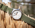 Luminox xl 1907 nf Atacama Field Automatic Herenhorloge 45mm met wit wijzerplaat en groene nylon band, outdoor stijl op gebroken hout. Swiss Made herenhorloge voor avontuurlijke stijl.