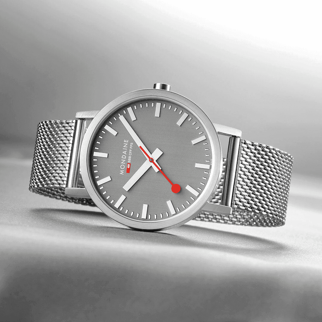 Mondaine Classic Spoorweg Horloge 40mm M660.30360.80SBJ met grijze wijzerplaat, rood secondewijzer en roestvrijstalen mesh band. Swiss Made heren horloge.