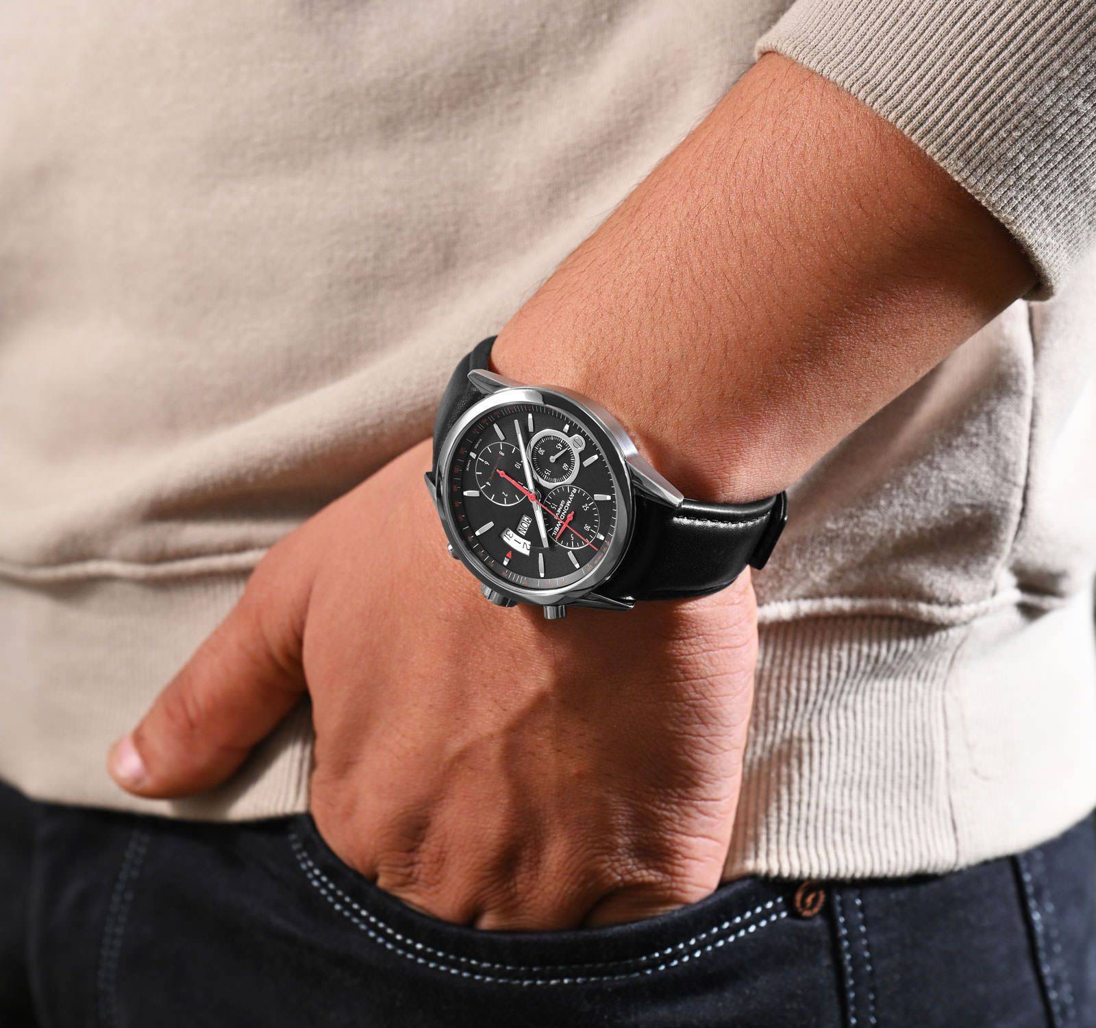 Raymond Weil Freelancer 42mm horloge met zwart leren bandje en chronograaf wijzerplaat, gedragen om de pols van een man in casual outfit.